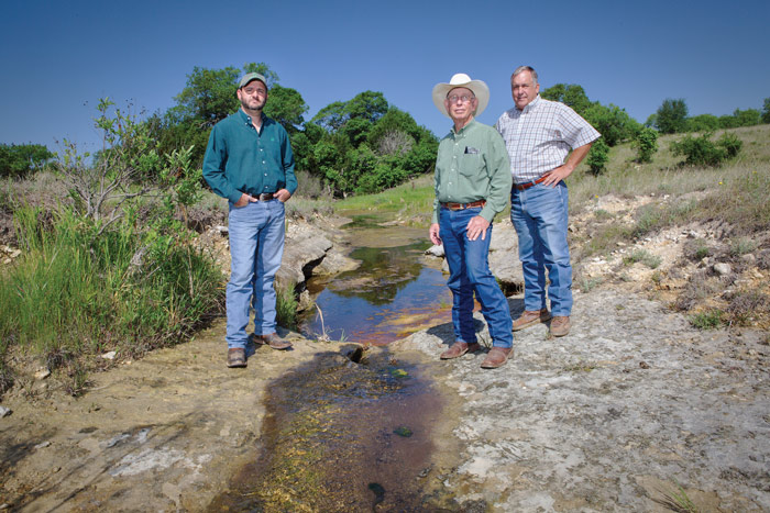 Texas rancher Jule Richmond, center, stands by a spring that feeds into the Pecan Bayou. With him are Cody York of Pecan Bayou SWCD, left, and Johnny Oswald of the Texas Soil and Water Conservation Board. Photos by Jim Lincoln.